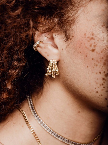 Mujer modelo posando con pendientes dorados de cuatro aros con piedras circonitas de la marca de joyas AmaloA.