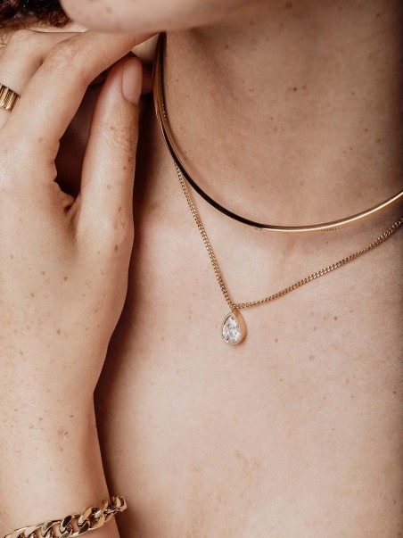 Modelo luciendo collar doble con un choker rígido y un colgante en forma de gota con circonita de la marca AmaloA.