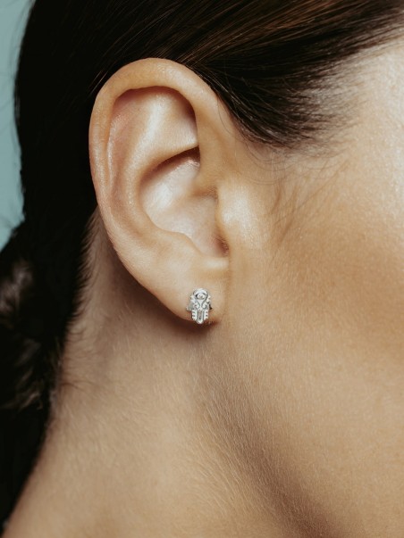 Modelo con pendientes en forma de mano de fátima de la marca de joyas AmaloA.