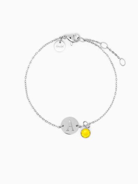Pulsera plateada con la letra A y una circonita de color amarillo de la marca de joyas, AmaloA.